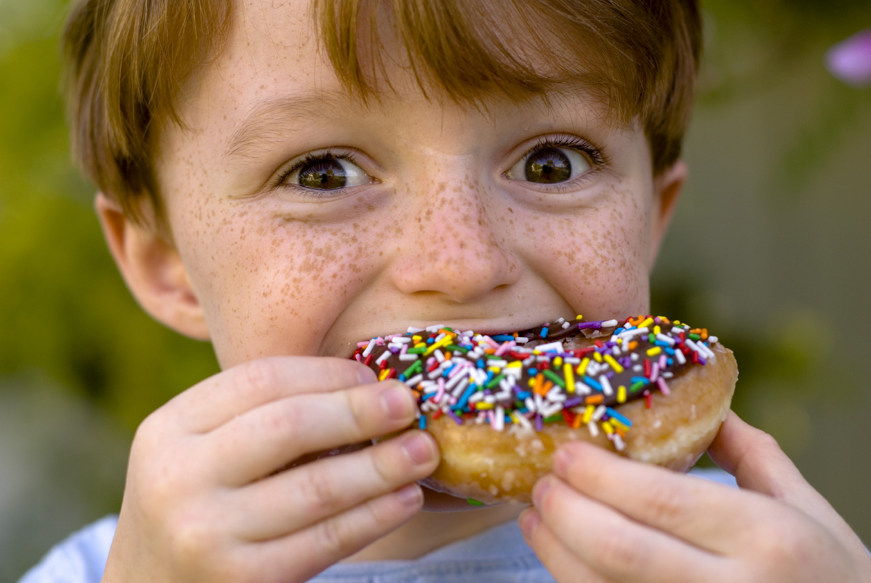 Kid eating fresh LaMars Donut | AZ, CO, NE, MO, KS